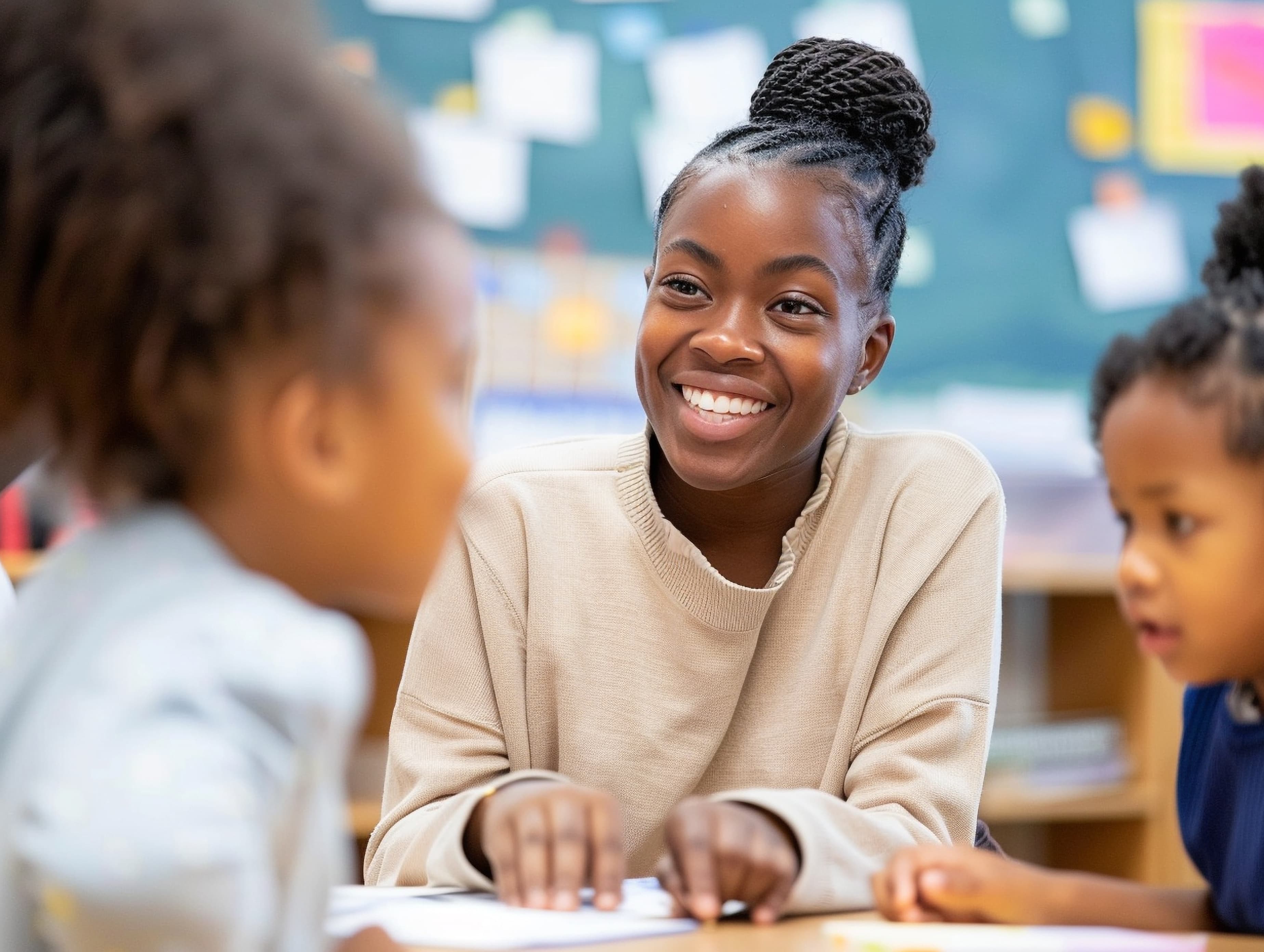 Smiling educator engaging with students in a bright classroom